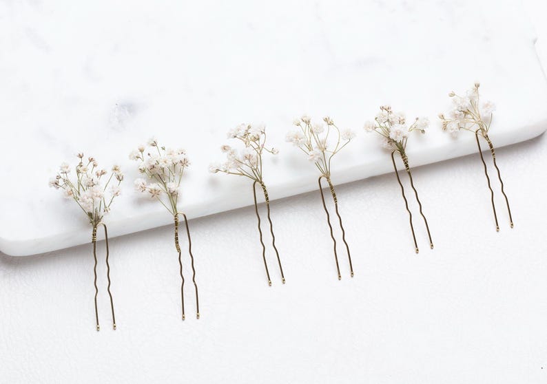 May include: Six gold hair pins with white baby's breath flowers attached.