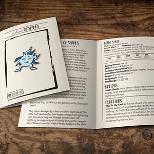 May include: Open booklet on a wooden surface. The cover reads "a shower of SPARKS" with a blue and white cartoon graphic. Inside, text describes "Giant Spark" stats and actions, including "Static Shock."