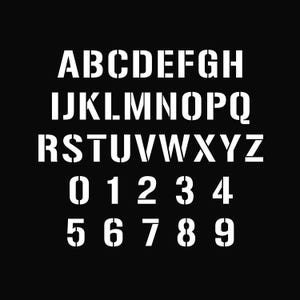 Könnte beinhalten: Weißes Schablonen-Schriftart des Alphabets und der Zahlen 0-9 auf schwarzem Hintergrund. Die Buchstaben sind in einem fetten, serifenlosen Stil gehalten, mit ausgeschnittenen Zentren. Die Zahlen sind ebenfalls in einer fetten Schablonenschrift.