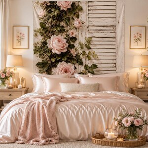 May include: A bedroom featuring a large wall tapestry depicting pink roses climbing a white wooden shutter. The bed is covered in a smooth, light pink satin duvet, matching pillowcases, and a textured pink throw blanket draped over the foot.