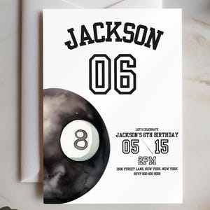 Peut inclure: Une carte d'invitation blanche avec le nom "JACKSON" et le numéro "06" en gras noir. Un graphique de boule de billard noire et blanche est à gauche. Le texte "LET'S CELEBRATE JACKSON'S 6TH BIRTHDAY" est également inclus, ainsi que la date, l'heure et l'adresse.