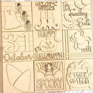 May include: A collection of nine unfinished wooden Halloween-themed squares. Each square features laser-cut designs, including a ghost, witch's boots, bats, a spider, candy corn, and the phrases "Welcome Witches," "Happy Halloween," and "Trick or Treat."