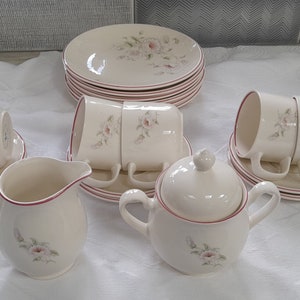 Può includere: Un set da tè bianco con disegni floreali. Il set comprende una teiera, un creamer, una zuccheriera e quattro tazze e piattini.
