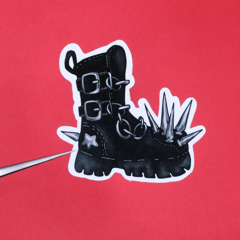 May include: Black leather boot with silver buckles and a chain. The boot has a star on the side and is covered in silver spikes.