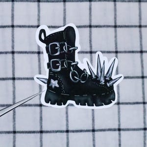 May include: Black leather boot with silver buckles and a row of silver spikes on the toe. The boot has a white star on the side.
