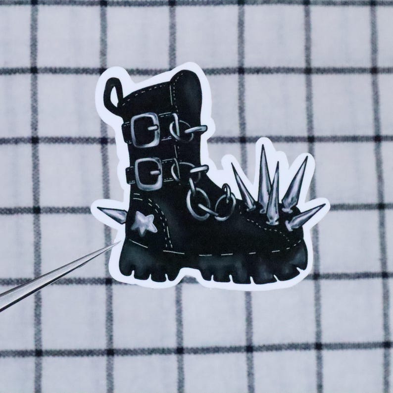May include: Black leather boot with silver buckles and a row of silver spikes on the toe. The boot has a white star on the side.