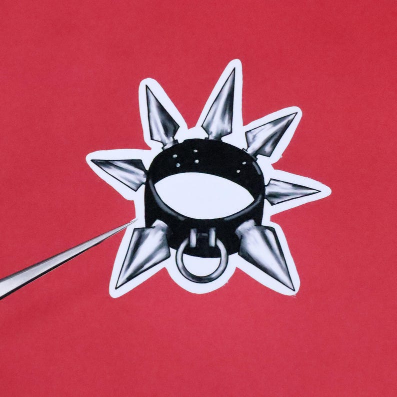 May include: A black leather choker with silver spikes. The choker has a silver ring at the back.