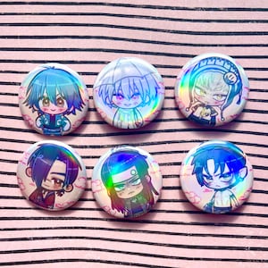 Może przedstawiać: Sześć okrągłych, holograficznych guzików w stylu anime. Każdy guzik przedstawia inną postać z niebieskimi, fioletowymi i zielonymi włosami, na tle różowych chmur. Guziki mają błyszczące wykończenie i są ułożone na różowo-białej, paskowanej powierzchni.