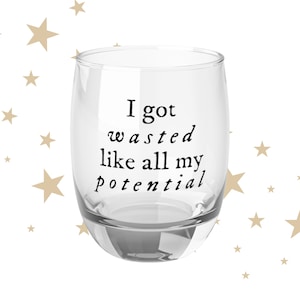 May include: A clear glass with a black inscription that reads "I got wasted like all my potential".