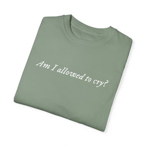 Puede incluir: Una camiseta verde salvia con el texto "Am I allowed to cry?" impreso en blanco.