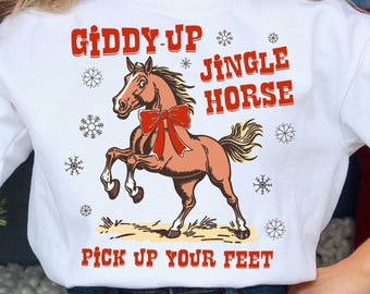 Puede incluir: Suéter blanco de Navidad con una ilustración de un caballo marrón y el texto "Giddy-Up Jingle Horse Pick Up Your Feet".