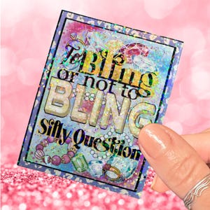 May include: A glittery card with the text "To bling or not to bling Silly Question" in a rainbow font. The card is decorated with jewels and beads.