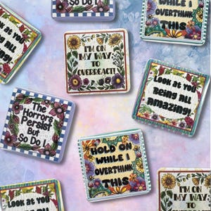 May include: Square magnets with floral borders and humorous text. The magnets feature phrases like "I'm on my way to overreact!" and "Look at you being all amazing!" The designs include sunflowers, daisies, and other colorful flowers.