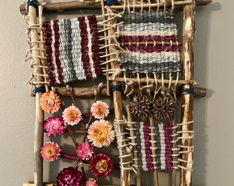 One of a kind handmade weaving using yarn, jute and straw flowers along with other objects found in nature.