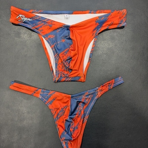 Könnte beinhalten: Ein Paar Unterwäsche mit orange-blauem Muster, tiefem Bund und einem Tanga-Rücken.