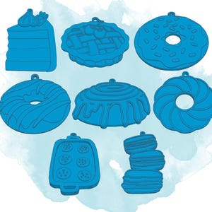 May include: Nine blue cookie cutters in various shapes, including a donut, a cake, a pie, a swirl, a cupcake, and a macaron. The cutters are all made of metal and have a shiny finish.