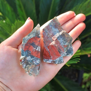 May include: Two pieces of red, green, and gray jasper stone. The stones are rough and have a natural, unpolished finish.