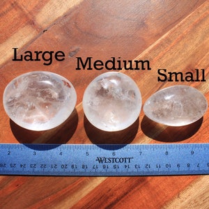 May include: Three clear quartz crystal stones of varying sizes labeled "Large", "Medium", and "Small" with a ruler for size comparison.