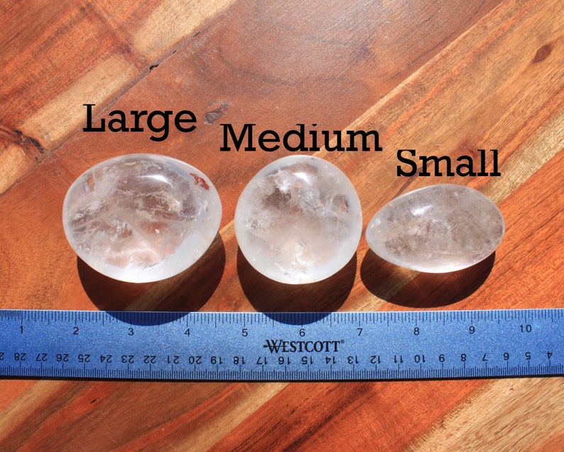 May include: Three clear quartz crystal stones of varying sizes labeled "Large", "Medium", and "Small" with a ruler for size comparison.