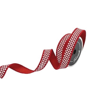 Puede incluir: Un carrete de cinta roja con un patrón de cuadros blancos en el centro. La cinta está parcialmente desenrollada, mostrando un reverso rojo sólido y un núcleo de carrete circular gris oscuro con el texto blanco Farrisilk impreso.