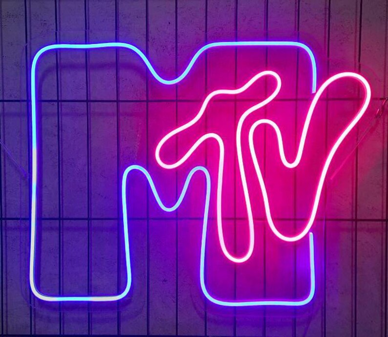 May include: A neon sign in the shape of the MTV logo. The "M" is outlined in blue and the "TV" is outlined in pink.