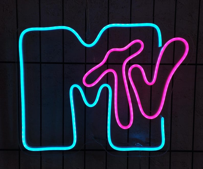 May include: A neon sign with the MTV logo. The logo is made of blue and pink neon tubing. The sign is mounted on a black wall.