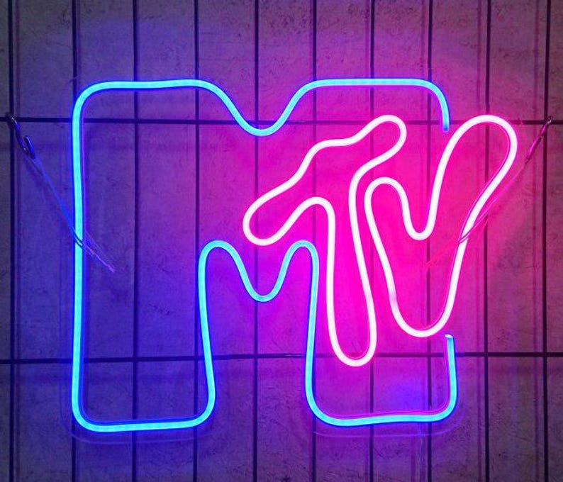 May include: A neon sign with the letters "MTV" in a blue outline and a pink interior. The "M" is shaped like a hand with the thumb pointing up.