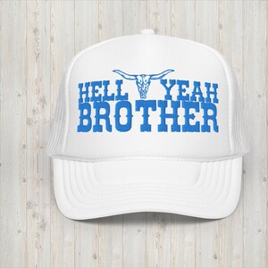 Könnte beinhalten: Weiße Trucker-Kappe mit einem blauen gestickten Design, das "Hell Yeah Brother" mit einem Stierkopf-Motiv über dem Text sagt.