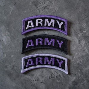 May include: Three embroidered patches with the word "ARMY" in white or purple lettering. The patches are arched and have a black or purple background. The patches are likely for military or tactical apparel.
