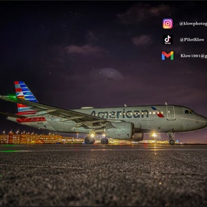 Może przedstawiać: Biały samolot American Airlines z czerwonymi, białymi i niebieskimi akcentami jest zaparkowany na pasie startowym w nocy. Samolot jest oświetlony światłami na pasie startowym i terminalem lotniska w tle. Niebo jest ciemne, a gwiazdy są widoczne.