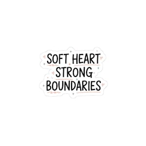 May include: A white sticker with the text "SOFT HEART STRONG BOUNDARIES" in black, with red lines and small heart and cross accents. The sticker has a white border and is set against a white background.
