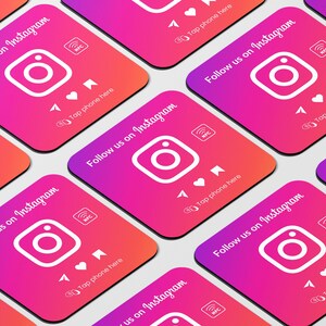 May include: A set of eight square coasters with a gradient pink and orange background. Each coaster features a white Instagram logo, the text "Follow us on Instagram", and a white NFC symbol. The coasters also have a white arrow pointing up and the text "Tap phone here".
