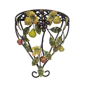 May include: A decorative metal wall basket with a fruit and leaf design. The basket features a dark brown frame with a lattice pattern at the top. It is adorned with green and yellow leaves, pears, apples, and grapes.