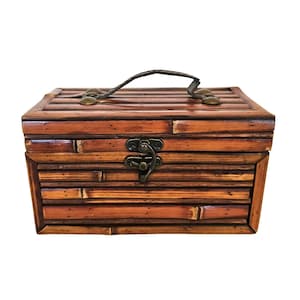 May include: A rectangular, brown bamboo box with a handle and a metal clasp. The box is constructed from horizontal bamboo strips, giving it a rustic appearance. The handle is made of a dark, woven material.