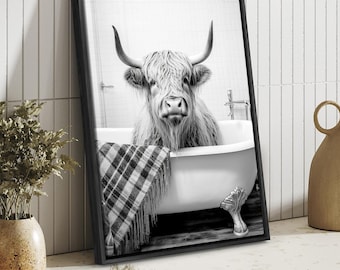 Può includere: Fotografia in bianco e nero di una mucca delle Highlands in una vasca da bagno con una coperta a quadri. La mucca guarda direttamente la fotocamera. La foto è incorniciata in una cornice nera.