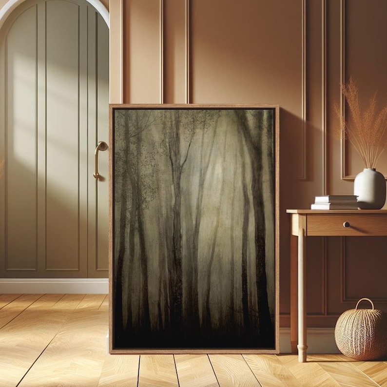 K&ouml;nnte beinhalten: Ein gerahmter Leinwanddruck einer nebeligen Waldszene mit hohen B&auml;umen und einer weichen, ged&auml;mpften Farbpalette. Der Druck ist in einem Holzrahmen und h&auml;ngt an einer Wand.