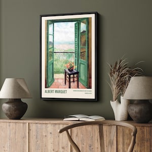 May include: A framed painting of a green door opening to a balcony overlooking a cityscape. The painting is by Albert Marquet and is titled "Window overlooking the Bay of Algiers, painted in 1913."