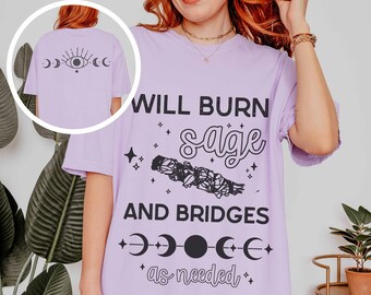 May include: A lavender t-shirt with the text "WILL BURN sage AND BRIDGES as needed" and a graphic of a sage bundle and moon phases.