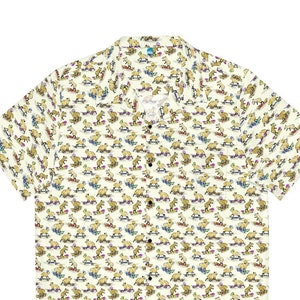 May include: A white short-sleeved button-down shirt with a repeating pattern of brown capybaras riding skateboards. The capybaras are wearing colorful hats and sunglasses.