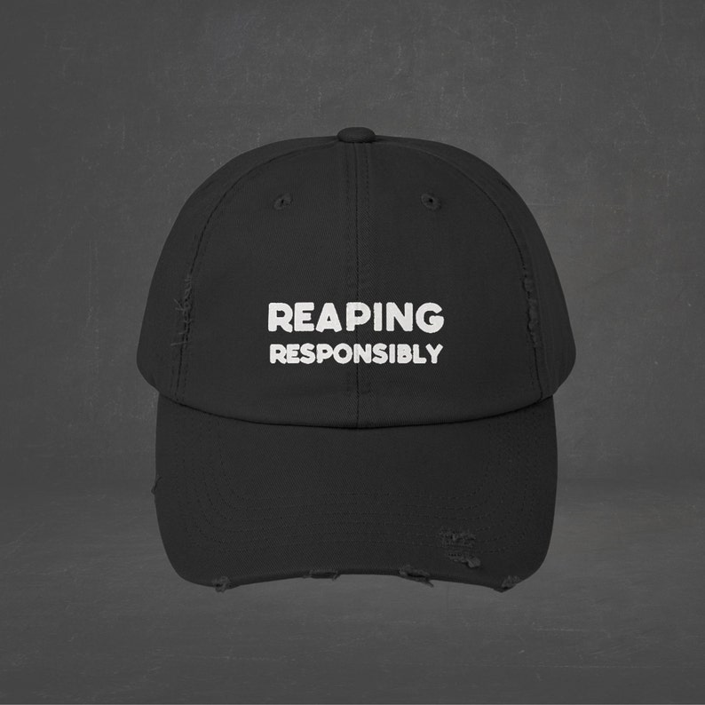 May include: Black distressed baseball cap with white embroidered text that reads "REAPING RESPONSIBLY".