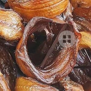 May include: Close-up of several dried apricots, showcasing a variety of shapes and shades of brown and orange. Some are wrapped in clear plastic. The textures range from smooth to slightly wrinkled, highlighting the natural variations.