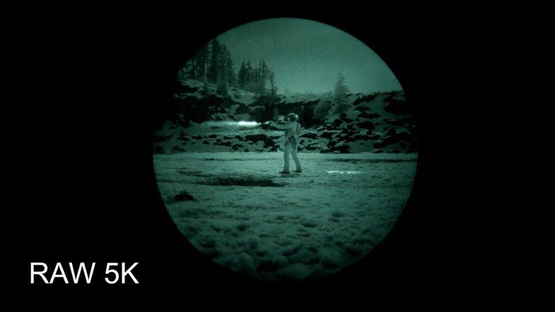 Puede incluir: Una persona con un traje blanco se encuentra de pie en un campo nevado, iluminado por una luz verde. La escena se captura a trav&eacute;s de una lente circular, creando un efecto de visi&oacute;n nocturna. El texto "RAW 5K" es visible en la parte inferior de la imagen.