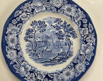 Assiette à pain et beurre dans le motif Liberty Blue par Staffordshire. Bordure florale bleue et blanche, scènes au centre 6 po.