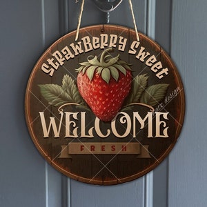 May include: A round wooden sign with a red strawberry and green leaves. The sign says "Strawberry Sweet" and "Welcome Fresh" in a vintage font.