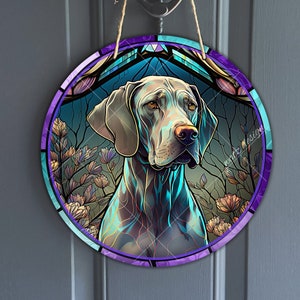 Puede incluir: Un colgante de pared redondo de estilo vitral con un perro Braco Alemán de Pelo Corto sobre un fondo azul y morado. El perro está rodeado de flores y hojas.