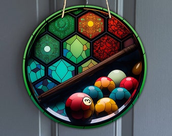 Può includere: Un'appendice da parete rotonda, verde e nera con un design a vetri colorati di un tavolo da biliardo con una stecca e palle da biliardo. Le palle sono rosse, gialle, verdi e bianche.