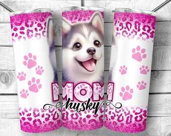 Op de afbeelding: Een roze en witte tumbler met een schattig husky puppy-ontwerp en de tekst "Mom Husky". De tumbler heeft een roze glitterontwerp en poot afdrukken.