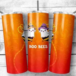 May include: Three orange and red stainless steel tumblers with a Halloween theme. The tumblers feature a design of two ghosts wearing witch hats and bee wings. The text "BOO BEES" is printed on the tumblers.