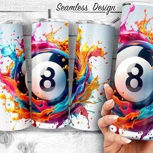 Puede incluir: Un vaso blanco con un diseño de salpicaduras de pintura de colores y una bola de billar negra y blanca en el centro.