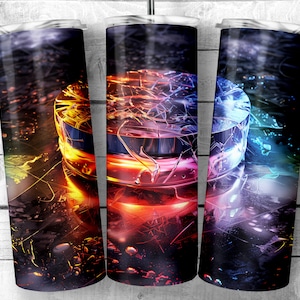 May include: A set of three stainless steel tumblers with a colorful abstract design. The design features a circular shape with a cracked, shattered effect in shades of red, orange, yellow, blue, and green. The background is a dark, textured surface.